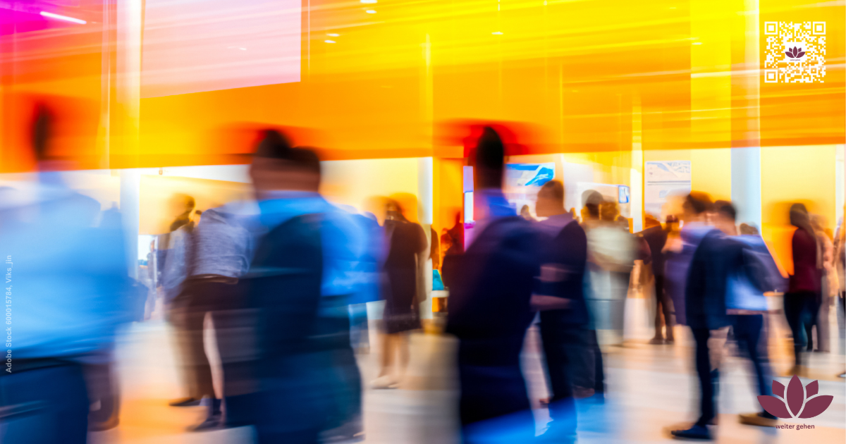 Unscharfe Menschen in Bewegung in einem hellen Innenraum mit warmen Gelb- und Orangetönen